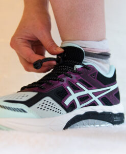 Athlete tying elastic no-tie shoe laces with lock